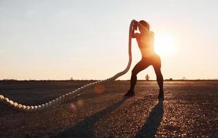 Frau im Sportbekleidungstraining mit Knoten auf der Straße zur Abendzeit foto