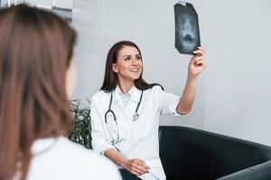 zeigt Röntgenergebnisse. junge frau hat einen besuch bei einer ärztin in einer modernen klinik foto