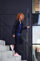 junge europäische rothaarige frau geht draußen auf der treppe spazieren foto