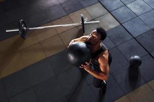 Basketball spielen. starker afroamerikanischer mann in sportlicher kleidung hat einen trainingstag im fitnessstudio foto