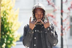 junger afrikanisch-amerikanischer Mann in schwarzer Jacke im Freien in der Stadt foto