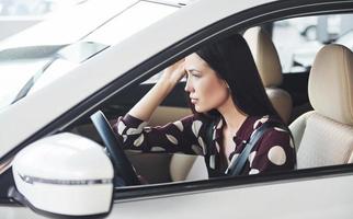 Seitenansicht der schönen jungen Brünette, die innerhalb des modernen Automobils. Auto fahren foto