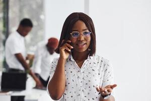 Porträt einer Frau mit Brille. gruppe afroamerikanischer geschäftsleute, die gemeinsam im büro arbeiten foto