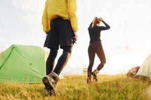 paar, das draußen in der nähe des grünen zeltes spazieren geht. Konzeption des Reisens foto