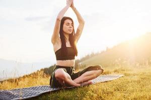 Yoga im Freien machen. schöne Frau. majestätische Karpaten. schöne Landschaft unberührter Natur foto