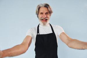 fröhlicher kellner macht selfie. Senior stilvoller moderner Mann mit grauem Haar und Bart drinnen foto