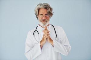 professioneller positiver Arzt. älterer stilvoller moderner mann mit grauem haar und bart zuhause foto