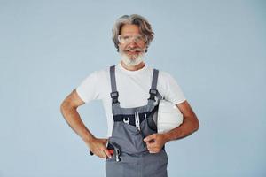 Handwerker bereit für die Arbeit. älterer stilvoller moderner mann mit grauem haar und bart zuhause foto