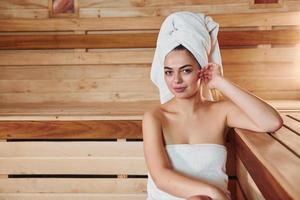 junge schöne frau ruht sich in der sauna aus. Konzeption der Körperpflege foto