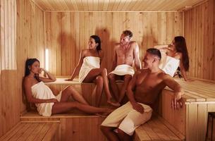 gruppe junger leute zusammen in der sauna. konzeption von urlaub und wochenende foto