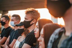 schöner Sonnenschein. Gruppe protestierender junger Menschen, die zusammenstehen. Aktivist für Menschenrechte oder gegen die Regierung foto