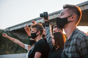 Fotograf mit Kamera. Gruppe protestierender junger Menschen, die zusammenstehen. Aktivist für Menschenrechte oder gegen die Regierung foto