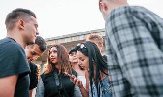 reden und lachen. gruppe junger fröhlicher freunde, die zusammen spaß haben. draußen feiern foto