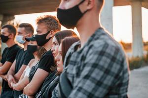 schöner Sonnenschein. Gruppe protestierender junger Menschen, die zusammenstehen. Aktivist für Menschenrechte oder gegen die Regierung foto