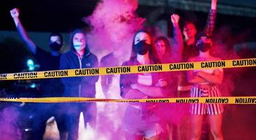 Rauch, Fäuste, Polizei. Gruppe protestierender junger Menschen, die zusammenstehen. Aktivist für Menschenrechte oder gegen die Regierung foto