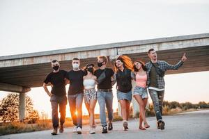 einander umarmen. gruppe junger fröhlicher freunde, die zusammen spaß haben. draußen feiern foto