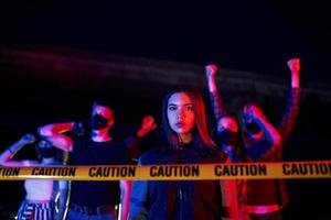 schöne Frau in der Nähe der Polizeigrenze. Gruppe protestierender junger Menschen, die zusammenstehen. Aktivist für Menschenrechte oder gegen die Regierung foto