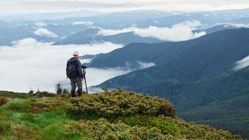 professioneller fotograf arbeitet mit kamera auf stativ. majestätische Karpaten. schöne Landschaft unberührter Natur foto