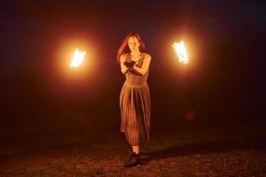 Feuershow von Frau im Kleid in den nächtlichen Karpaten. schöne Landschaft foto