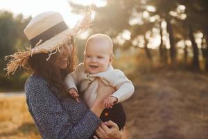 Die junge Mutter mit ihrem kleinen Baby ruht sich in der Herbstsaison im Freien aus foto