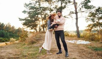 Einheit des Volkes. glückliche familie von mutter, familie und kleinem baby ruht im freien. schöne sonnige herbstnatur foto