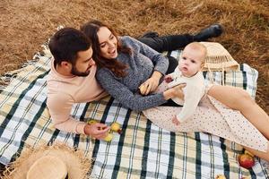 hat Picknick. glückliche familie von mutter, familie und kleinem baby ruht im freien. schöne sonnige herbstnatur foto