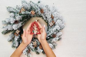 Frauenhände halten Spielzeug. Draufsicht der festlichen Weihnachtsbeschaffenheit mit Dekorationen des neuen Jahres foto