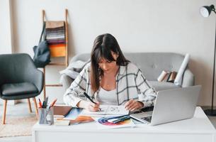 Papierkram erledigen. junge freiberufliche arbeiterin ist tagsüber zu hause foto