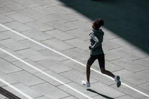 schneller Läufer. junge afroamerikanerin in sportlicher kleidung trainiert tagsüber im freien foto