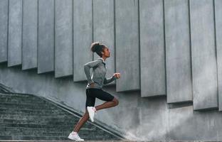 Konzeption des Sports. junge afroamerikanerin in sportlicher kleidung trainiert tagsüber im freien foto