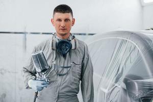 kaukasischer automechaniker in uniform arbeitet in der garage foto