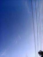 wunderschöne Naturkulisse im blauen Himmel, weiße Wolken und viele grüne Bäume drumherum foto