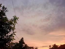 wunderschöne Naturkulisse im blauen Himmel, weiße Wolken und viele grüne Bäume drumherum foto