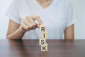 Geschäftsfrau hält einen Holzklotz in der Hand. das Wort Risiko eingeben. Risikoabsicherungskonzept. Beseitigung von Risiken. foto