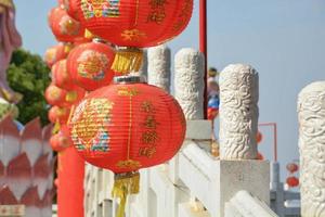 Chinesische rote Laterne hat glückliche und chinesische Musterdekoration geschrieben, die die weiße Brücke und das chinesische Design der Säule am Schrein hängt. foto