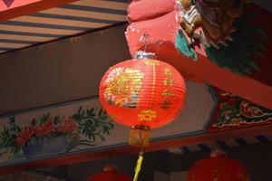chinesische rote laterne hat glückliches und chinesisches muster geschrieben, dekoration hängt im schrein. foto