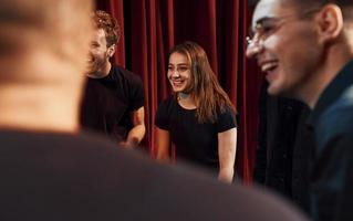 Gruppe von Schauspielern in dunkler Kleidung bei der Probe im Theater foto