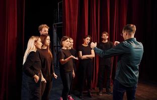 Gruppe von Schauspielern in dunkler Kleidung bei der Probe im Theater foto