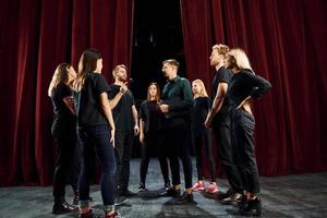 Gruppe von Schauspielern in dunkler Kleidung bei der Probe im Theater foto