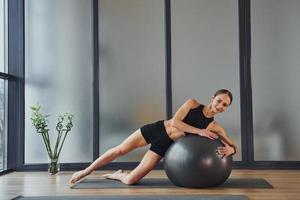 eine Pause machen. junge frau in sportlicher kleidung und mit schlankem körper haben fitness-yoga-tag drinnen foto