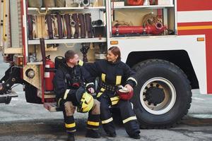 männliche und weibliche feuerwehrleute in schutzuniform sind gemeinsam im freien foto