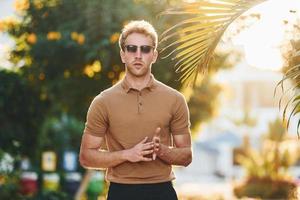 heller Sonnenschein. Der junge Mann ist tagsüber im Freien. Konzept des Urlaubs foto