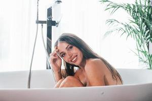 Schöne junge Frau hat Freizeit zu Hause im Bad foto