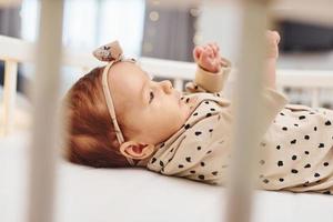 süßes neugeborenes baby legt sich tagsüber drinnen im bett hin foto