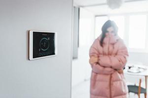 Problem mit der Temperatur. frau steuert drinnen die smart-home-technologie foto