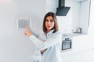 frau steuert drinnen die smart-home-technologie foto