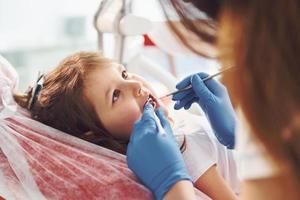 kleines mädchen, das zahnarzt in der klinik besucht. Konzeption der Stomatologie foto