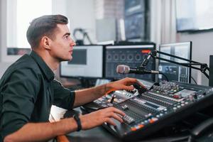 junger mann ist drinnen im radiostudio ist mit sendung beschäftigt foto