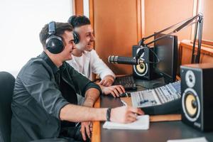 Zwei Jungs sind drinnen im Radiostudio und sind mit Sendungen beschäftigt foto