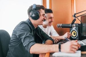 Zwei Jungs sind drinnen im Radiostudio und sind mit Sendungen beschäftigt foto